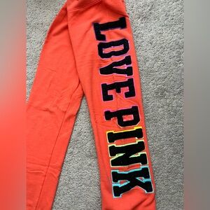 PINK Victoria's Secret Orange Sweatpants with Multicolor 'LOVE PINK' Leg Graphic